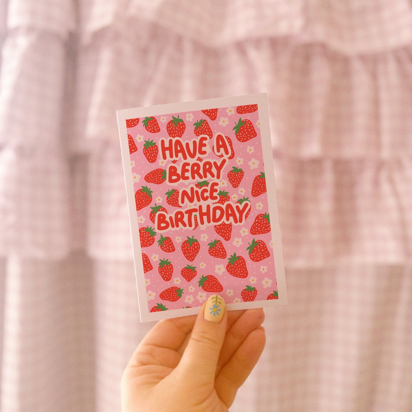 A pink and red card, with a strawberry pattern, and text saying 'have a berry nice birthday'.