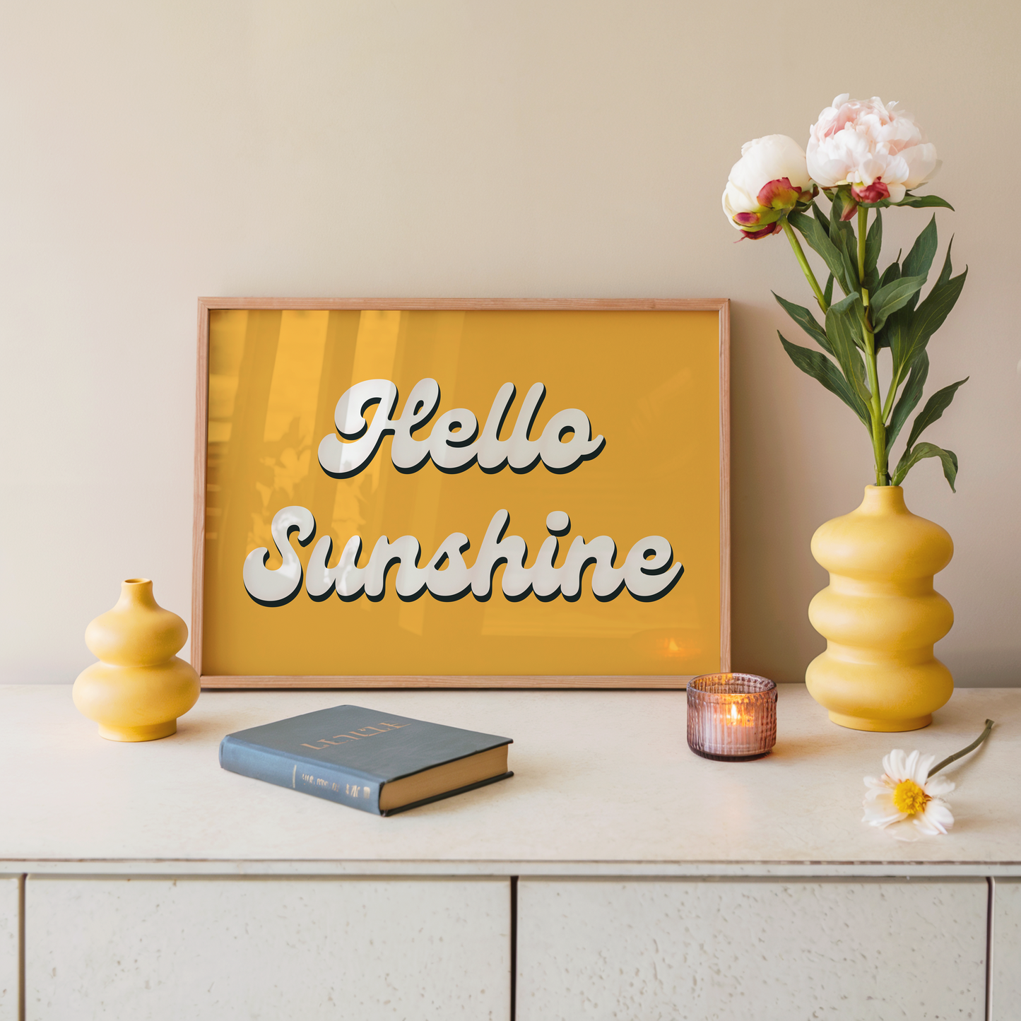 Decorative setup with 'Hello Sunshine' wall art, books, and flowers on a shelf.