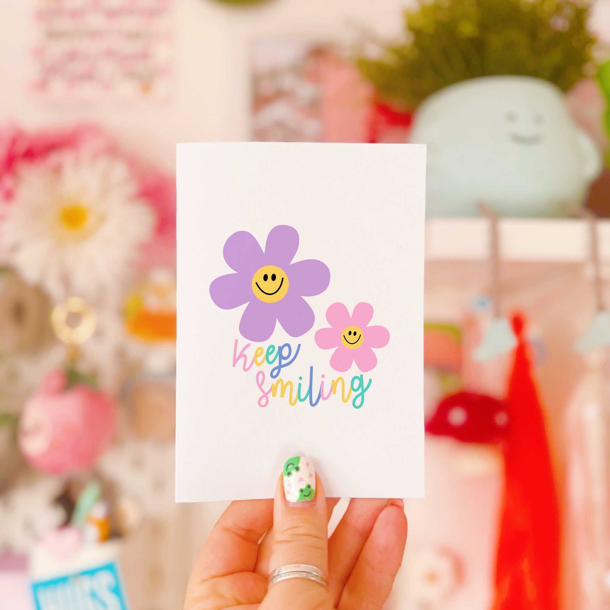 A card with two smiling flower illustrations and text that says 'keep smiling'.