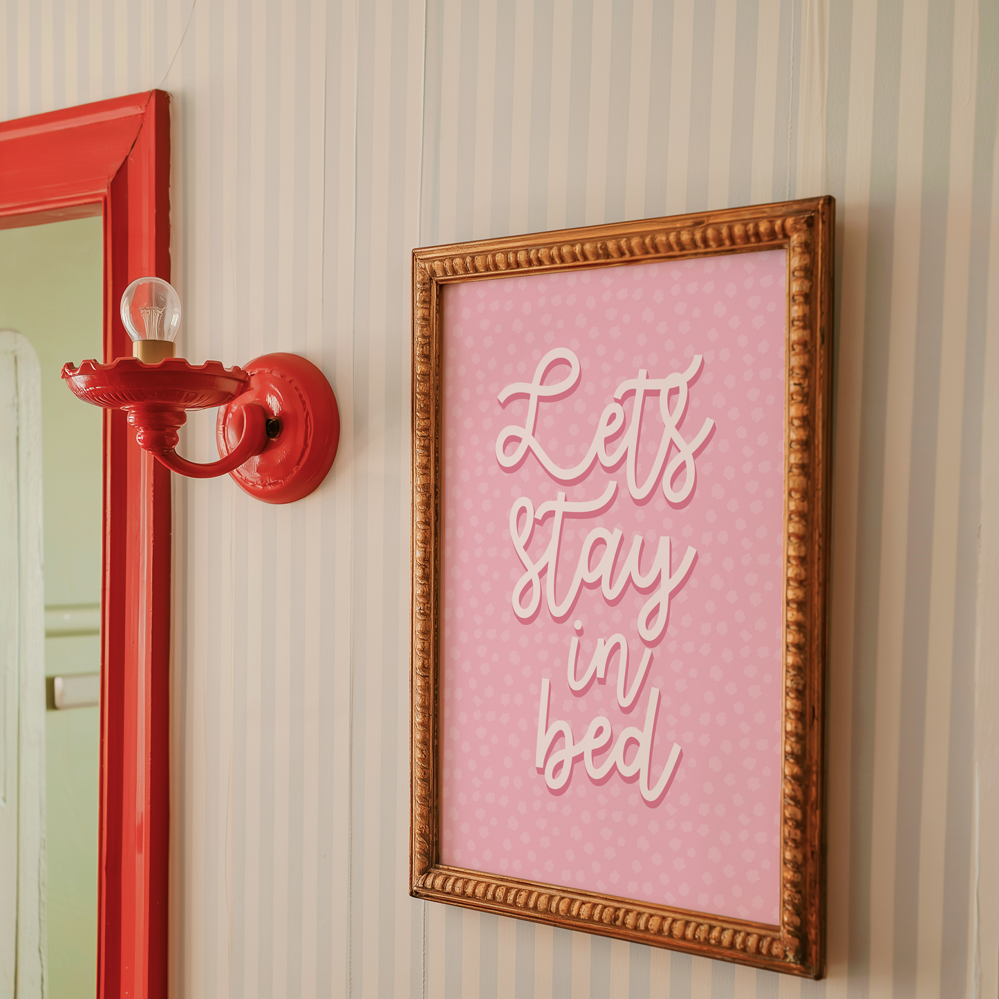 A pink polka dot print, with the words 'lets stay in bed' in a script font in the centre.