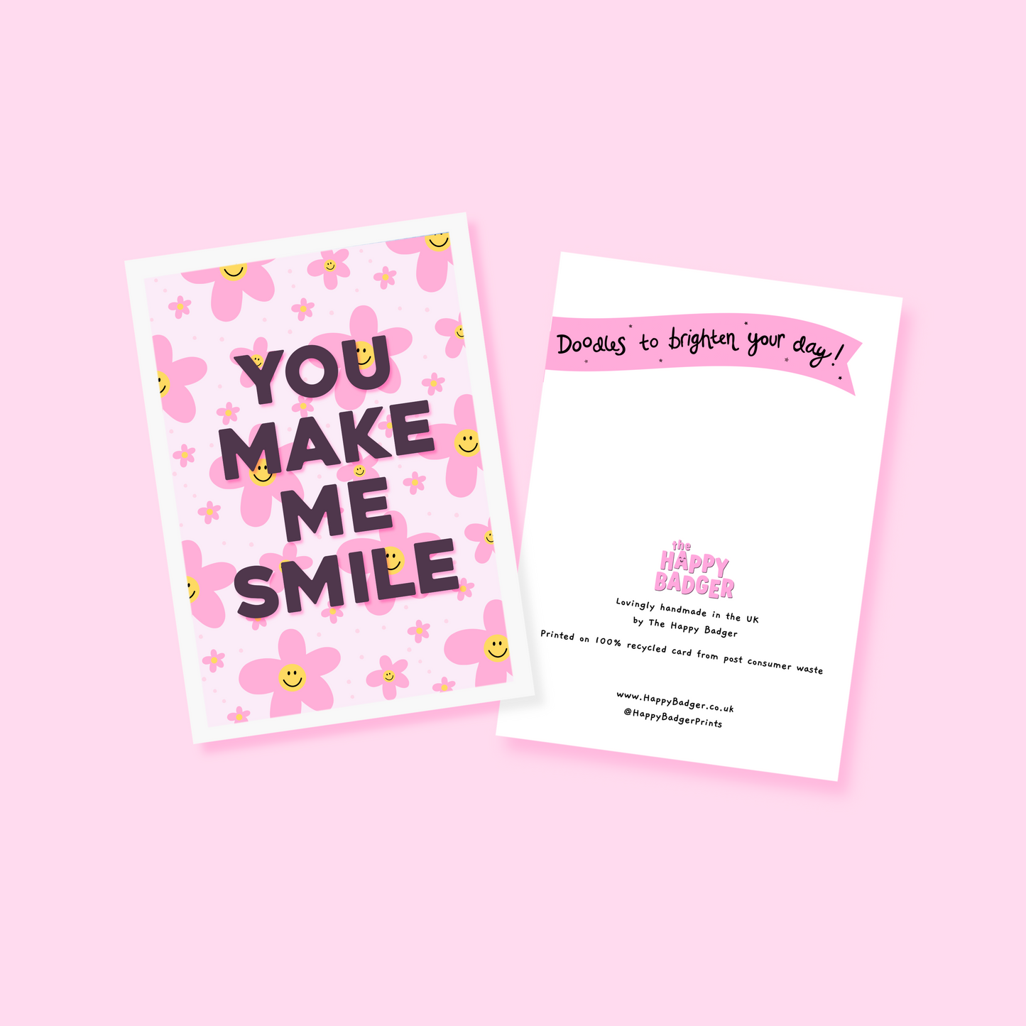 a card with pink smiling daisies on the background, and black text reading 'you make me smile'.