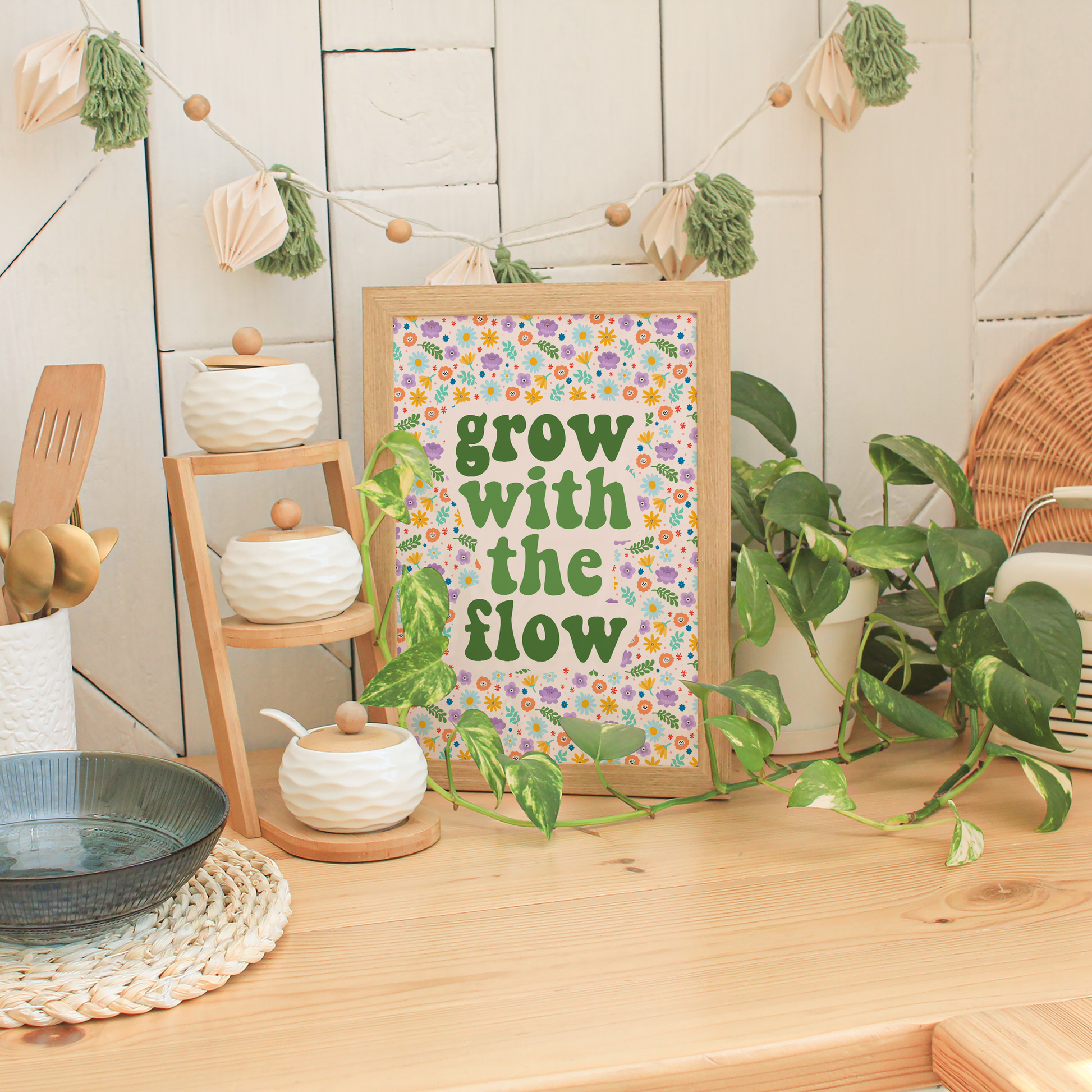A multicoloured floral background, with the quote 'grow with the flow' in green tones.