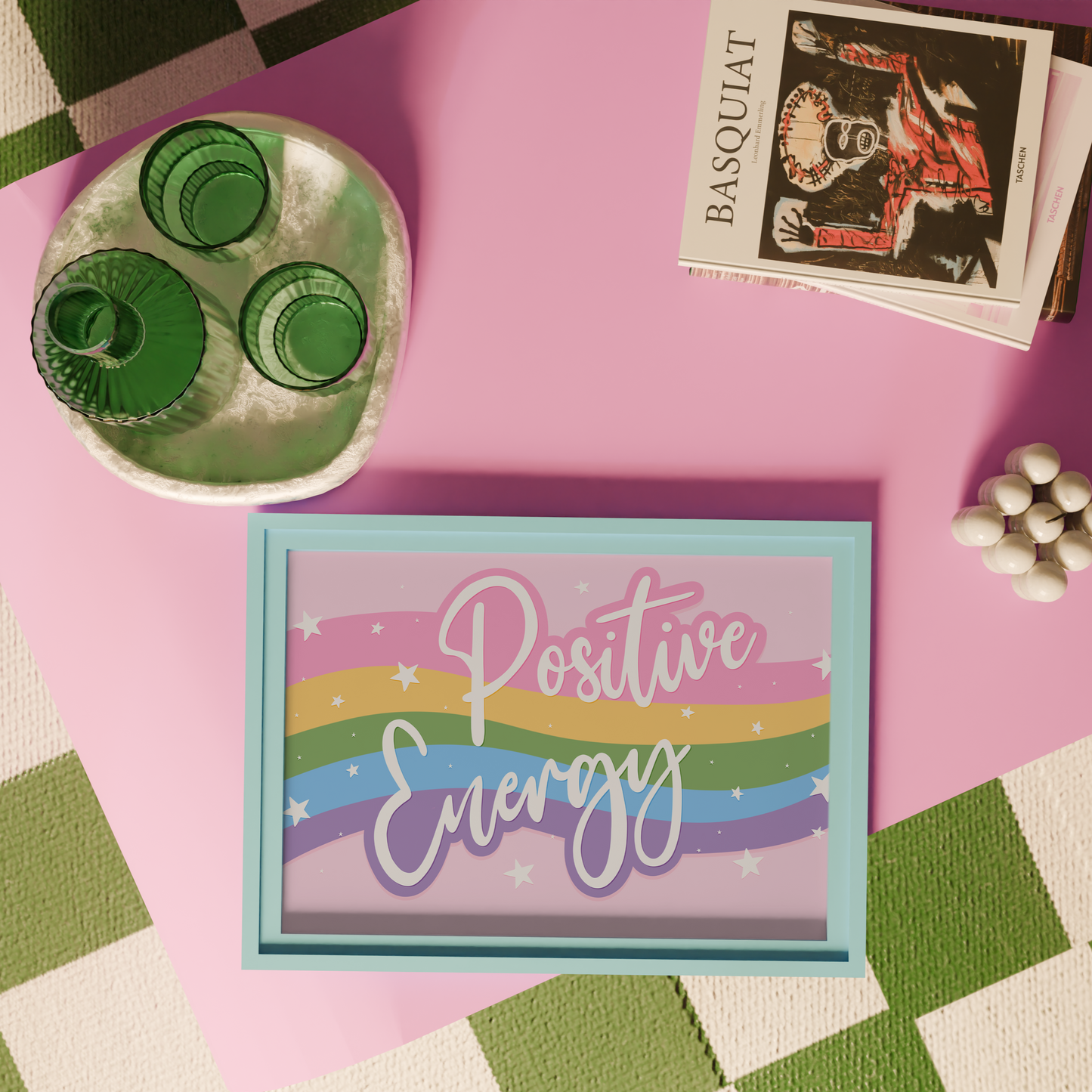 A bright print, with a pink, yellow, green blue and purple wave across the centre and the words 'positive energy' hand written in white across the top.