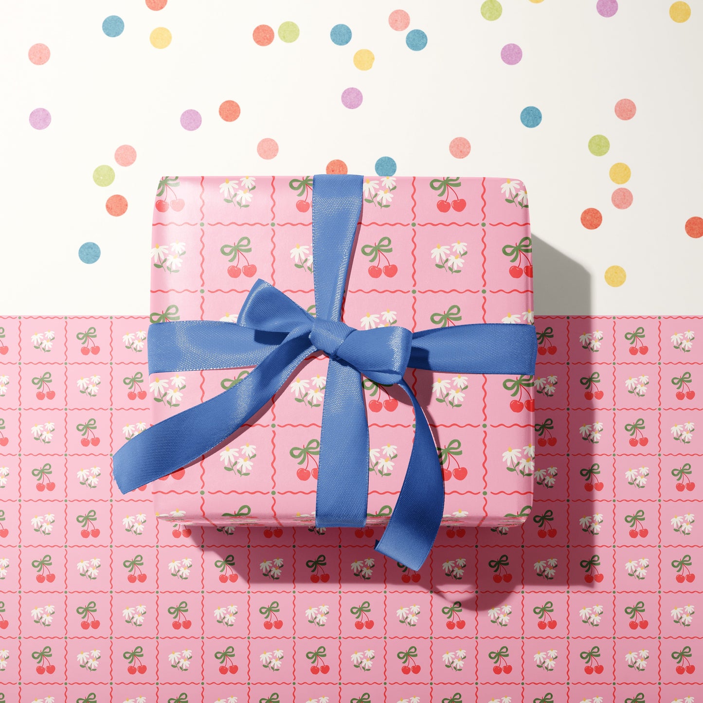 A pink patterned gift wrap, with cherries and daisies on.