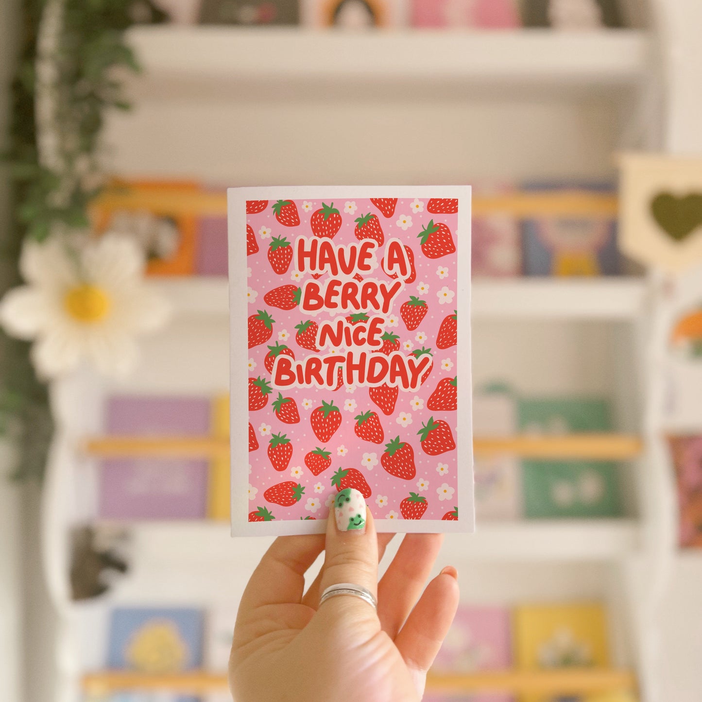 A pink and red card, with a strawberry pattern, and text saying 'have a berry nice birthday'.
