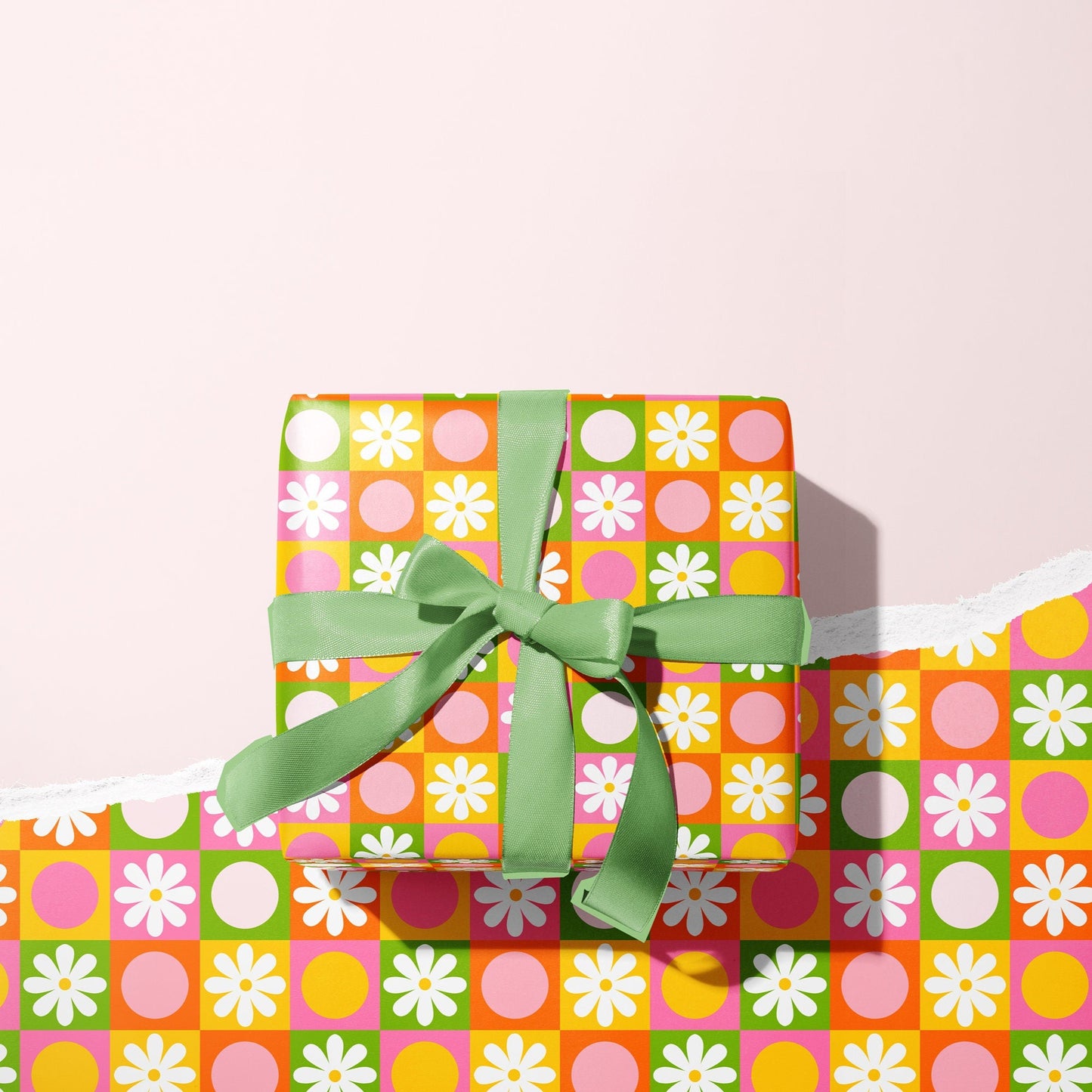 A gift wrapped present, wrapped up in a bright retro print gift wrap from The Happy Badger.