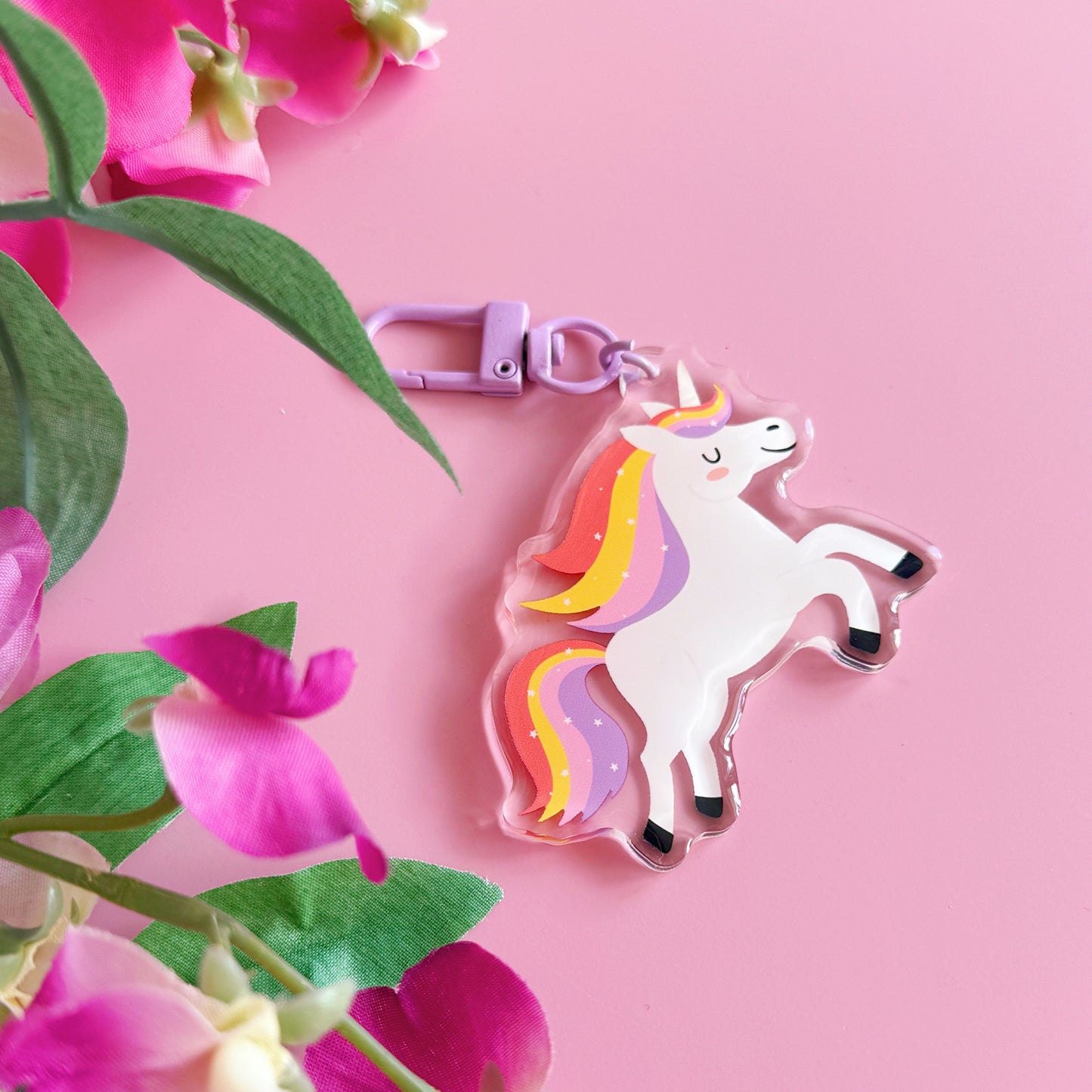 Unicorn keychain with pink flowers on a pink background