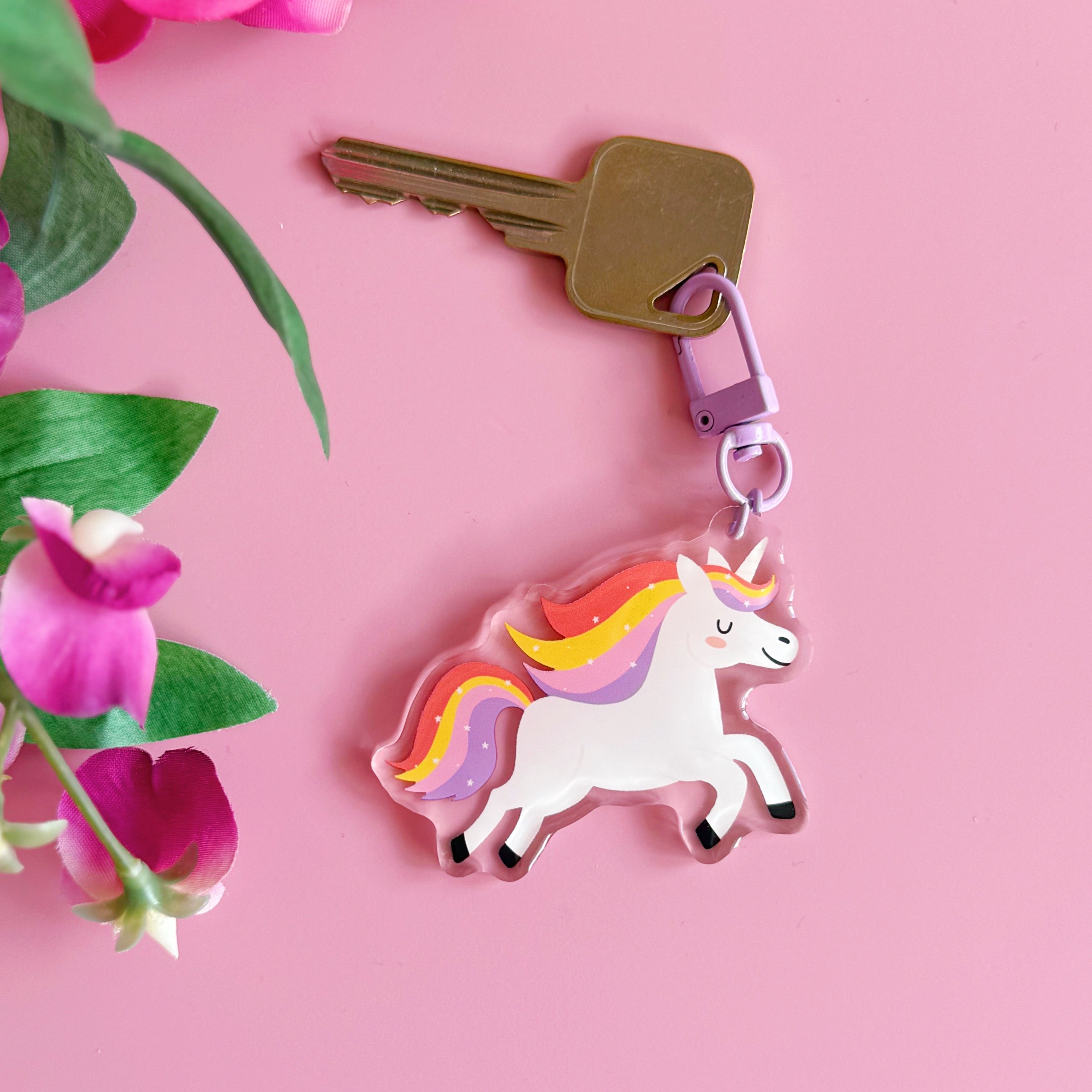 Unicorn keychain on a pink background with flowers