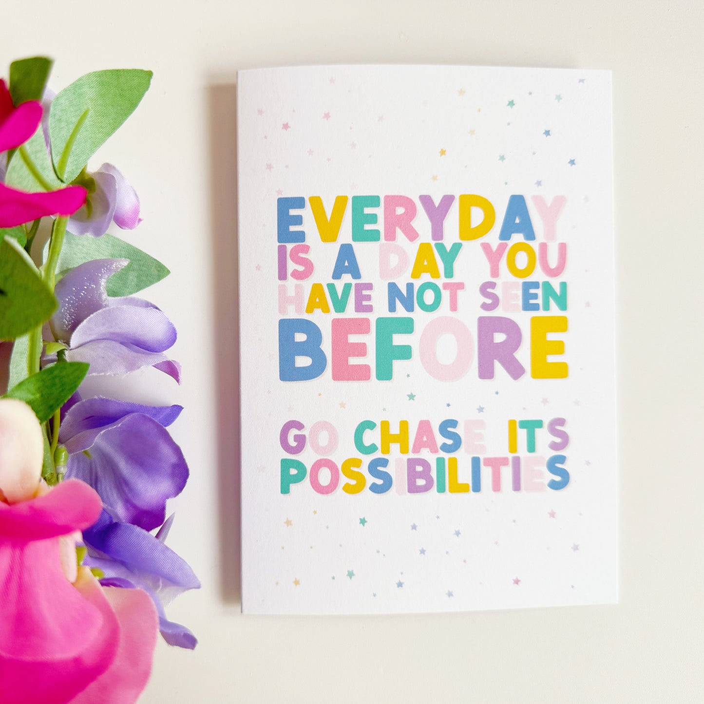 A greeting card with a positivity message; saying to go chase the possibilities of a new day.