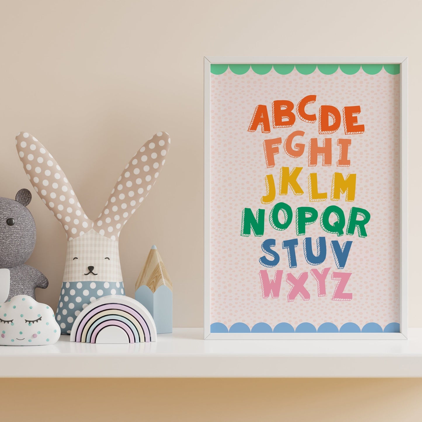 A colourful alphabet print, with a coordinating scallop border, shown in a frame.