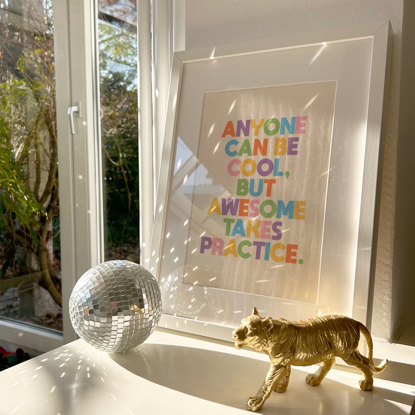 A typography print with a funny motivational quote on, in vibrant colours, shown in a frame.