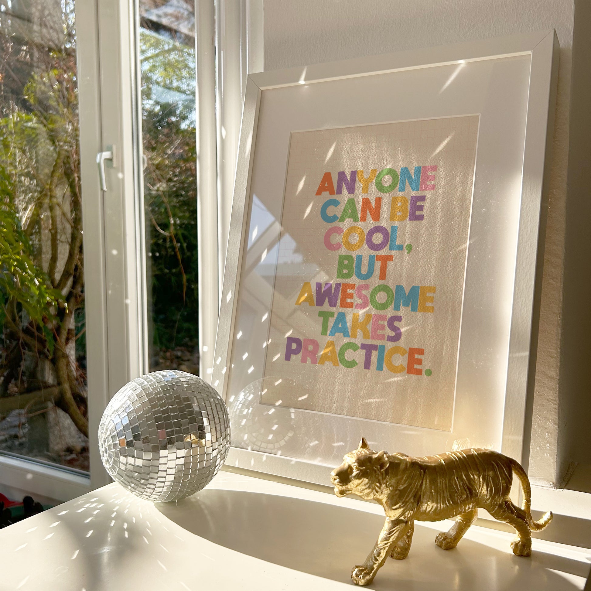 A typography print with a funny motivational quote on, in vibrant colours, shown in a frame.
