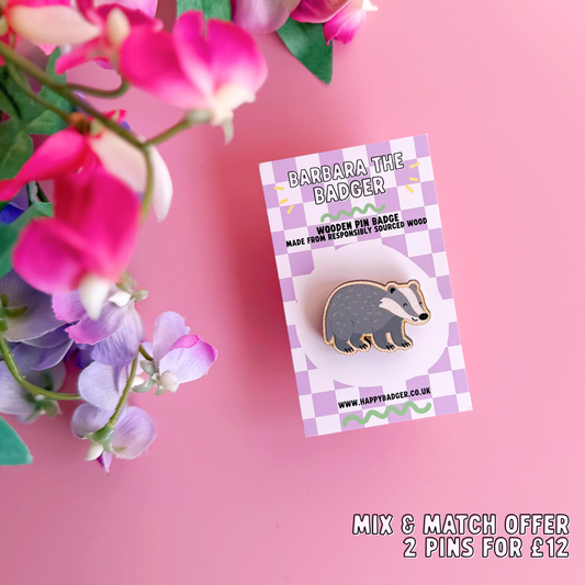A wooden pin badge with a glossy finish, featuring an illustration of a badger.