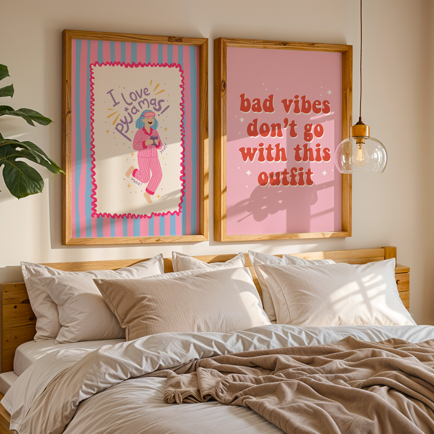 Two colourful prints, one saying  love pyjamas and the other saying bad vibes don't go with this outfit, shown above a cosy looking bed.