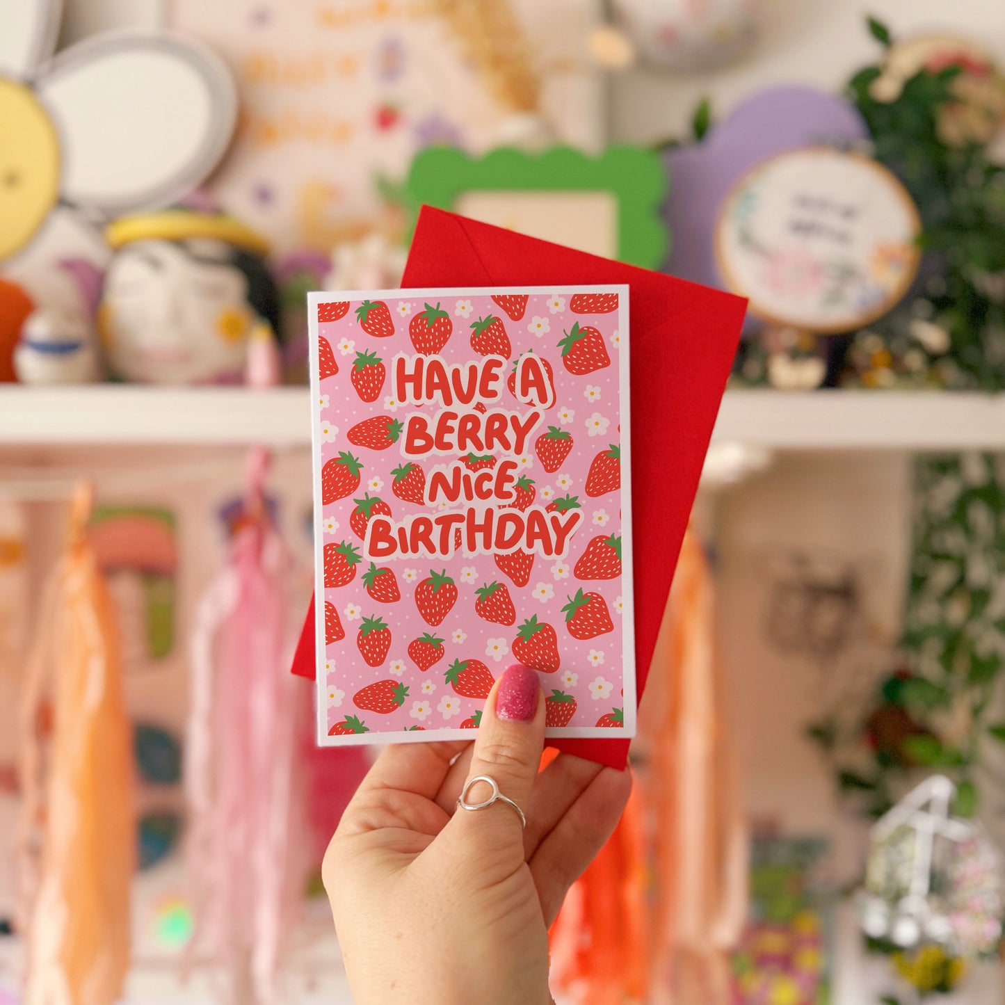 A card with a strawberry pattern, and text that reads 'have a berry nice birthday' in red.