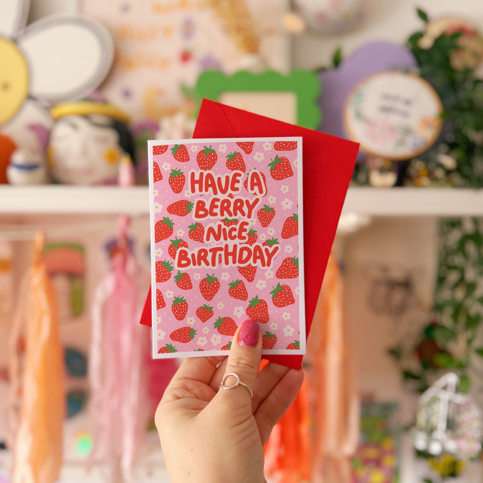 A card with a strawberry pattern, and text that reads 'have a berry nice birthday' in red.