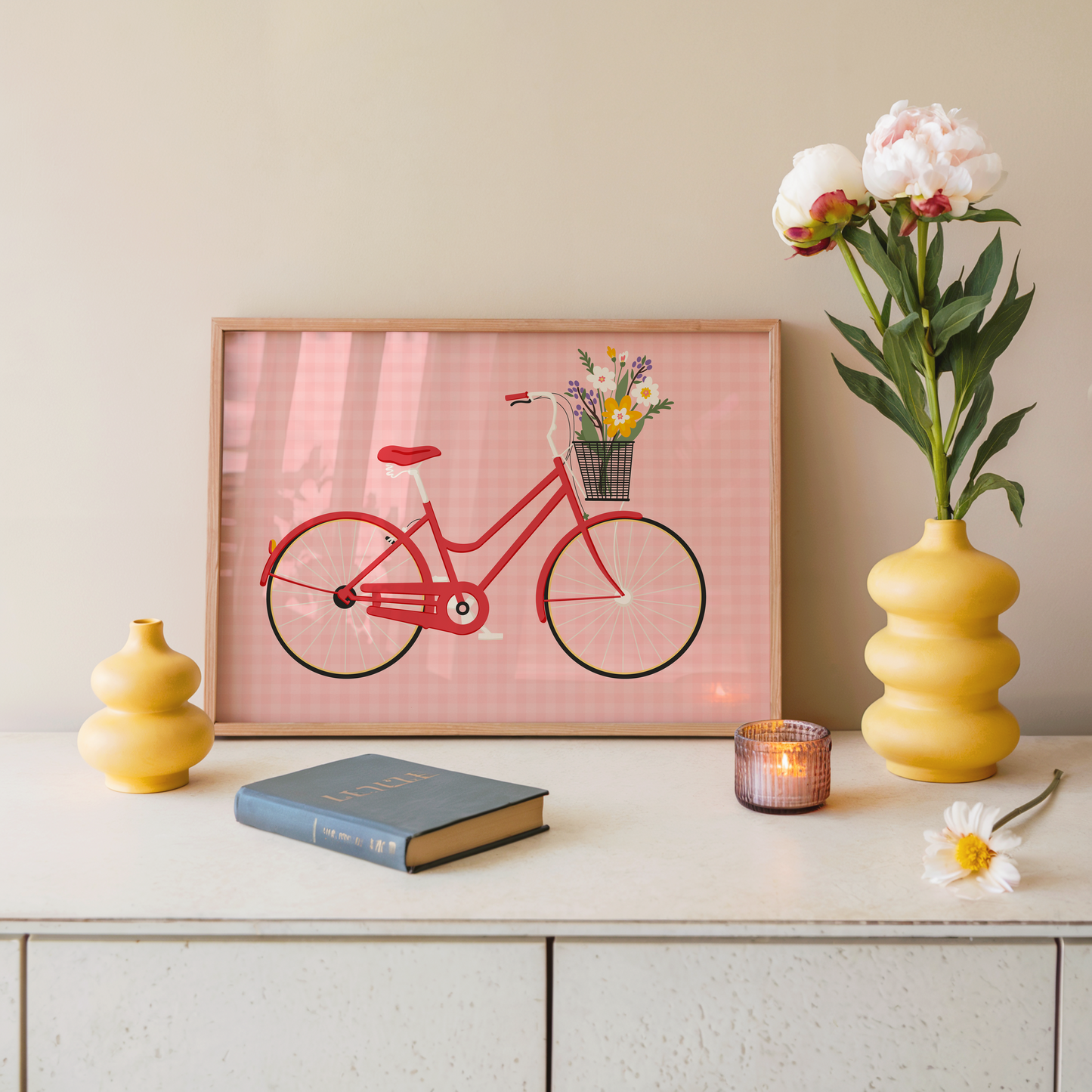 An illustrated print of a red bike with a basket, which is full of bright colourful flowers. The background of the print is a warm pink gingham pattern.