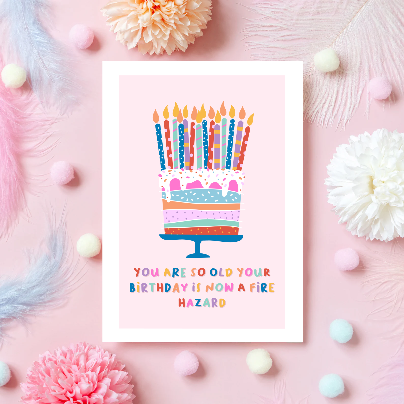 A card with a colourful birthday cake on the front, with several candles, and the words 'you are so old your birthday is now a fire hazard' underneath.