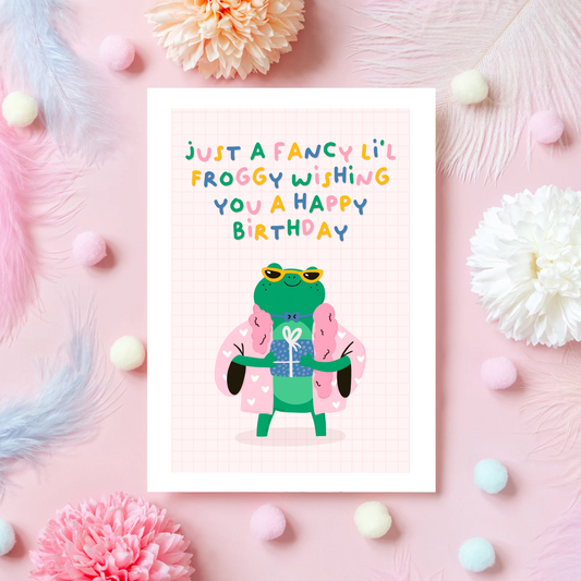 A birthday card with a green frog, dressed in fancy clothes, with text above saying 'just a fancy little froggy wishing you a happy birthday'