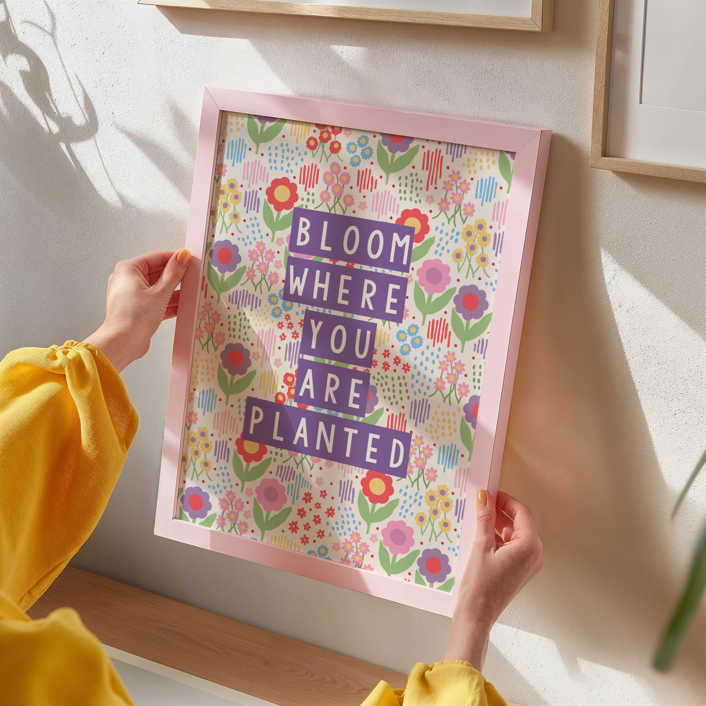 A colourful illustration of a floral background with purple text saying bloom where you are planted.