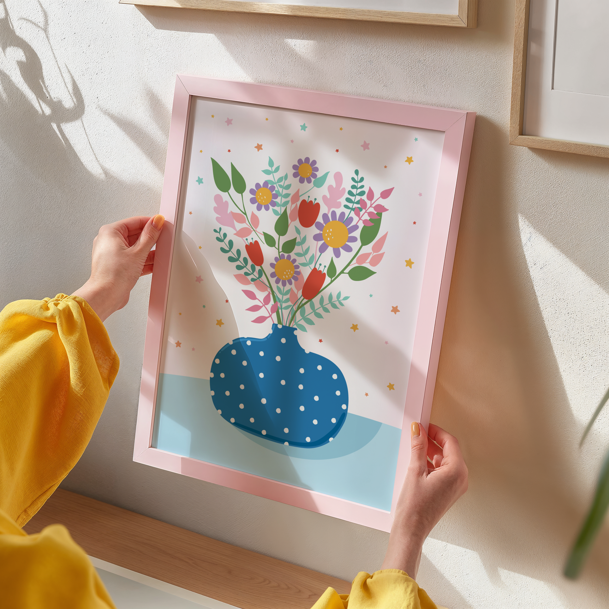 A bright blue print showing a polka dot vase with lots of vibrant hand drawn flowers in it.