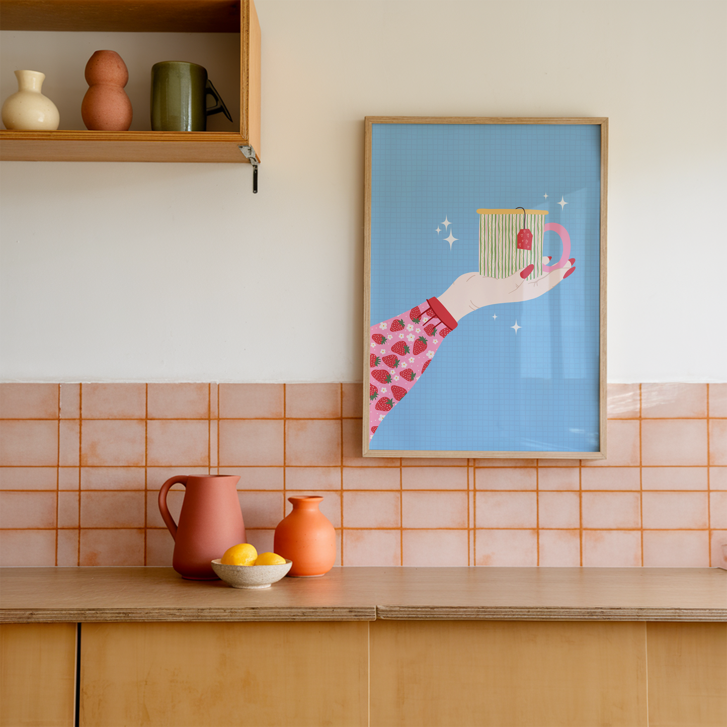A blue print with an illustration of an arm, wearing a strawberry patterned blouse/top, reaching out into the centre of the frame and holding a brightly coloured mug.