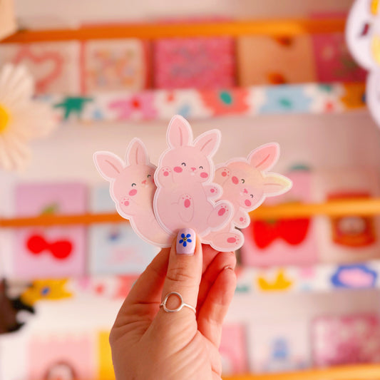 A holographic sticker of a cute smiling bunny rabbit.