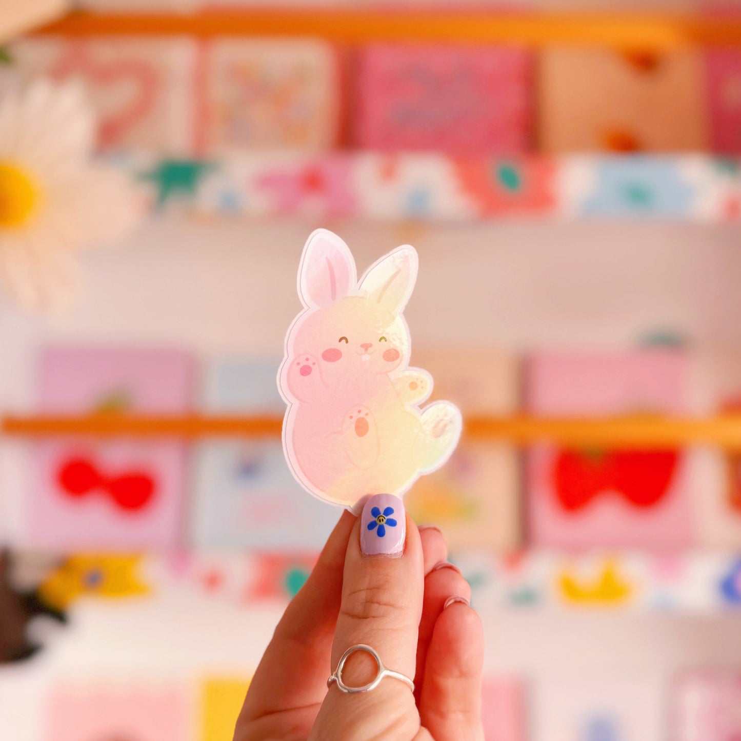 A holographic sticker of a cute smiling bunny rabbit.
