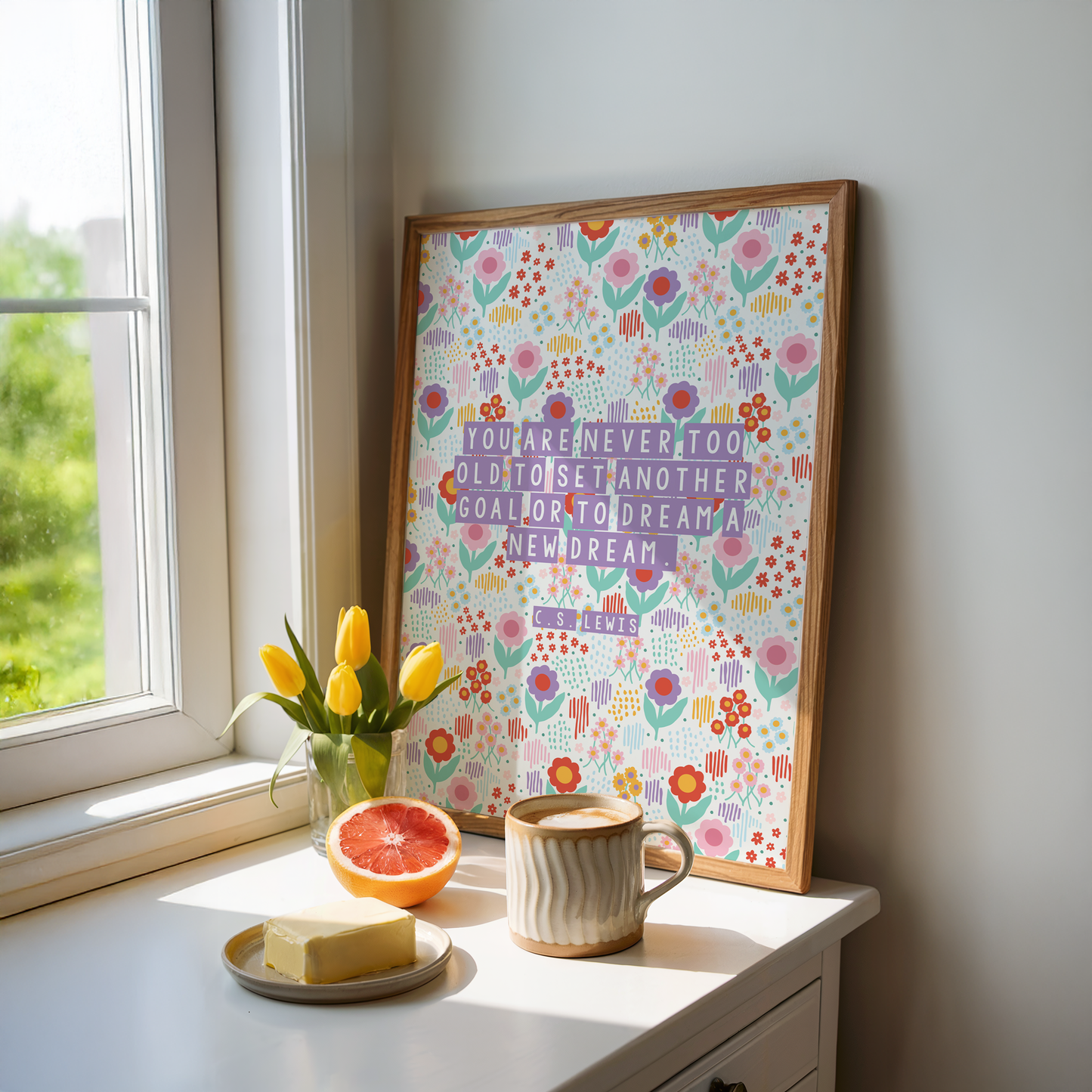 A brightly coloured floral print, with a motivational quote on the front by C.S. Lewis, stating you are never too old to set another goal or to dream a new dream.