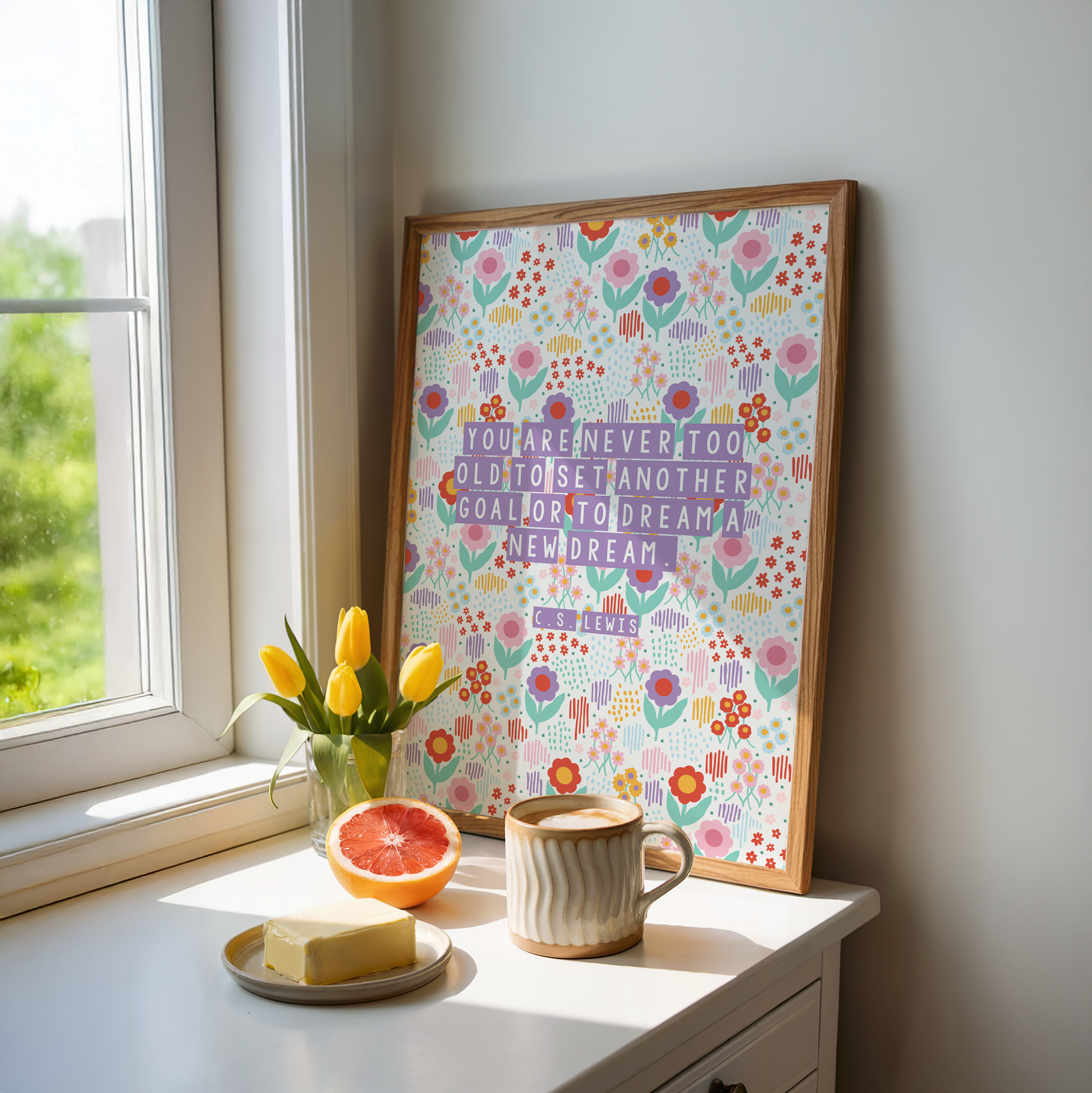 A brightly coloured floral print, with a motivational quote on the front by C.S. Lewis, stating you are never too old to set another goal or to dream a new dream.