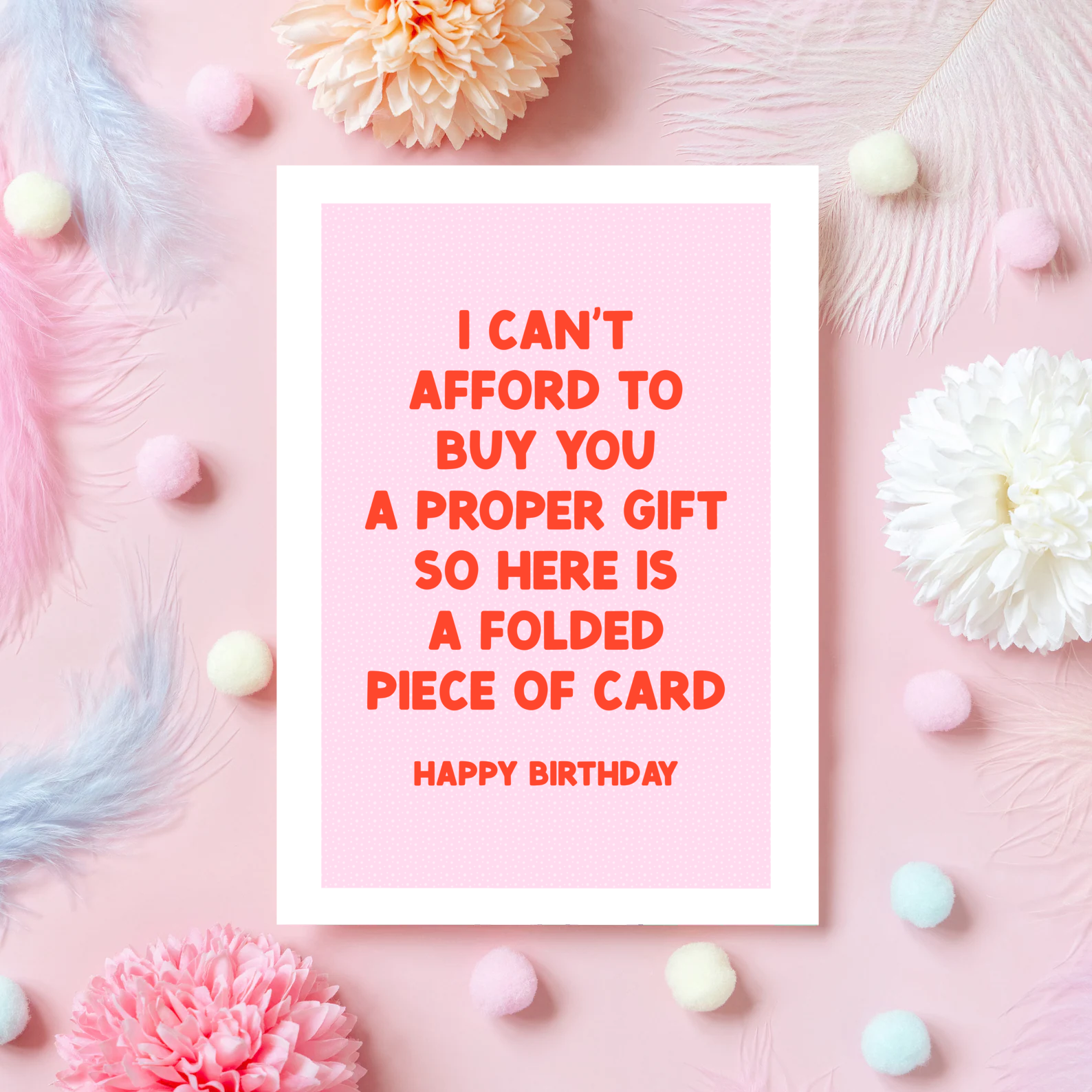 A pink card with red text, saying I can't afford to buy you a proper gift so here is a folded piece of card - happy birthday.
