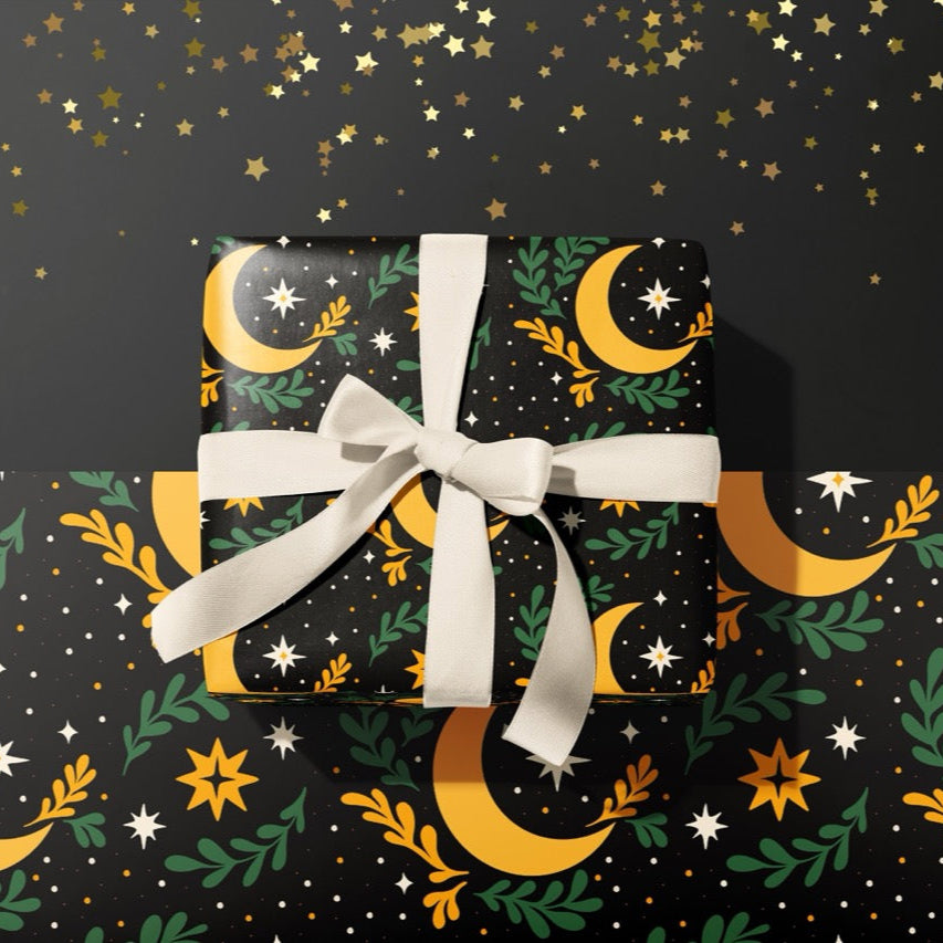 A gift wrapped present, wrapped up in celestial moon and stars print gift wrap from The Happy Badger.