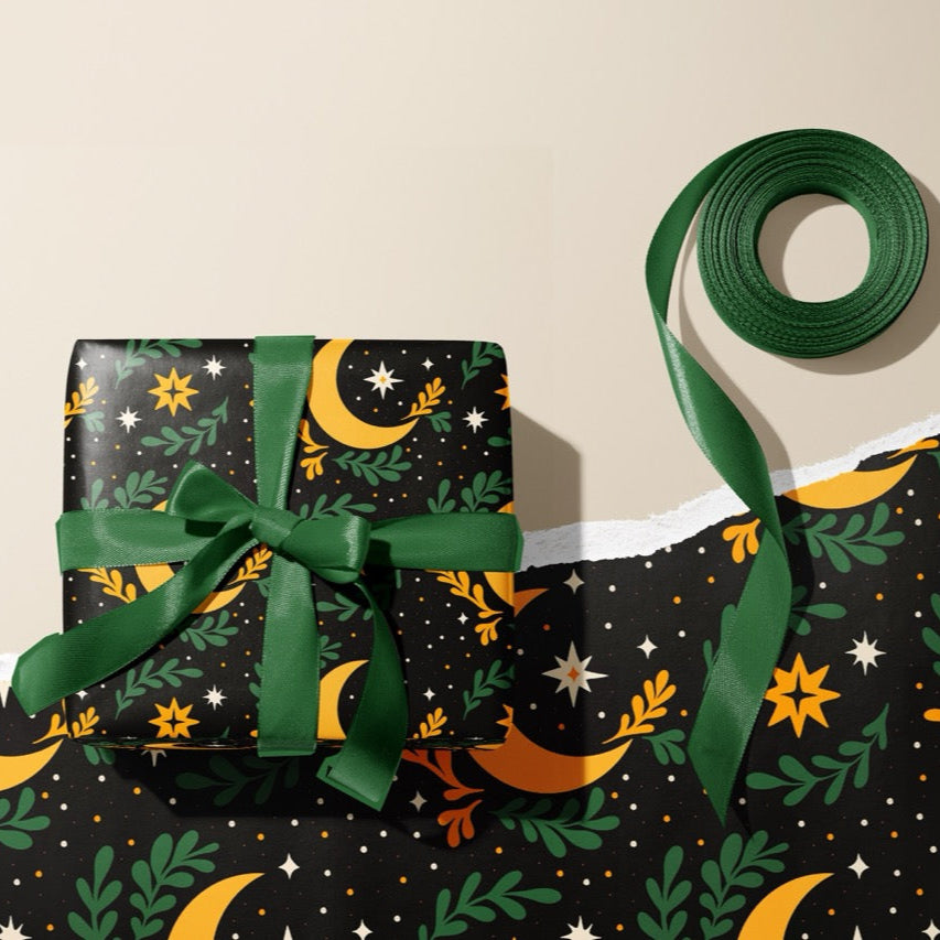 A gift wrapped present, wrapped up in celestial moon and stars print gift wrap from The Happy Badger.