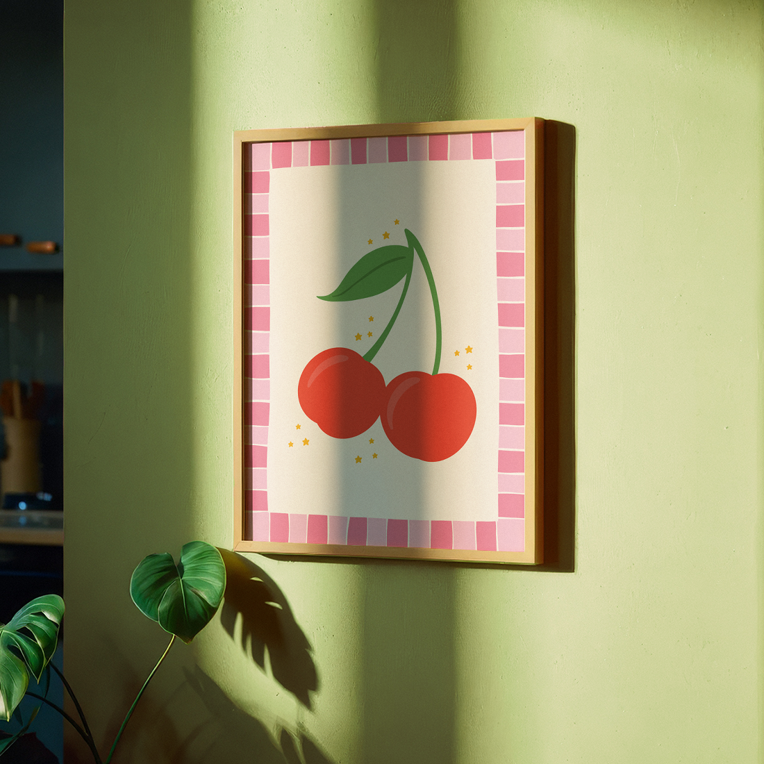 A print with an illustration of a pair of cherries, on a soft pink background surrounded by a bright pink hand drawn border.