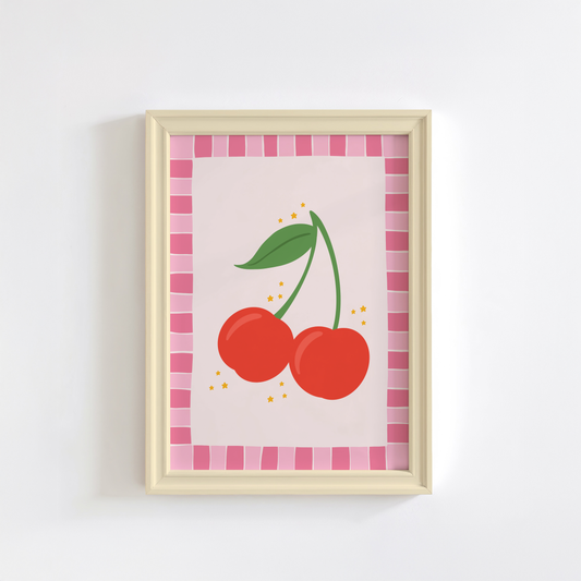 A print with an illustration of a pair of cherries, on a soft pink background surrounded by a bright pink hand drawn border.