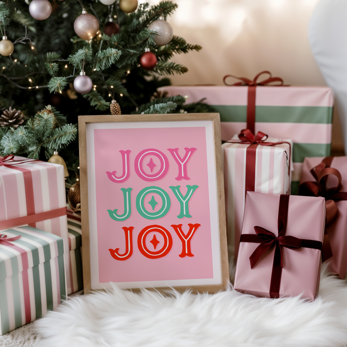 Framed artwork with 'JOY' text in different colors on a pink background