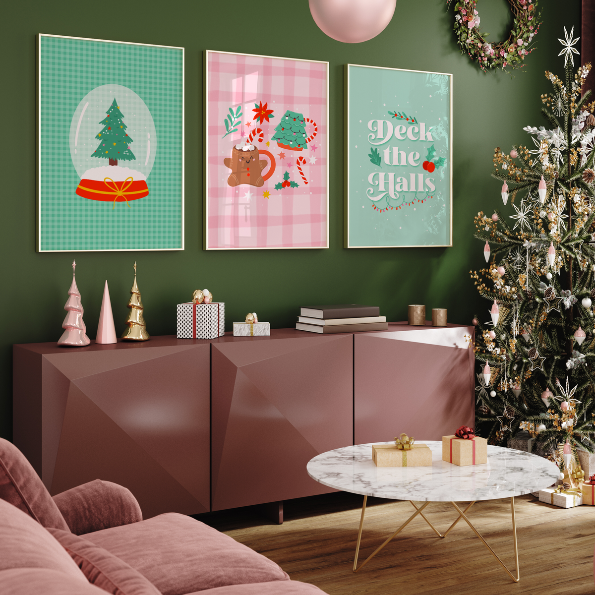 A collection of three pink and green Christmas prints shown in frames on a dark green wall, next to a Christmas tree.
