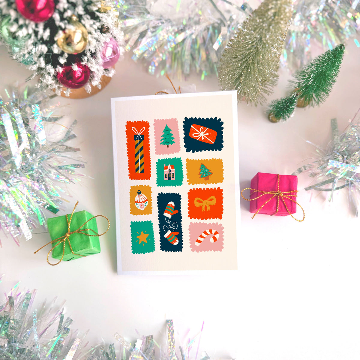 A Christmas card with lots of colourful squares and rectangles with Christmas illustrations inside of them.