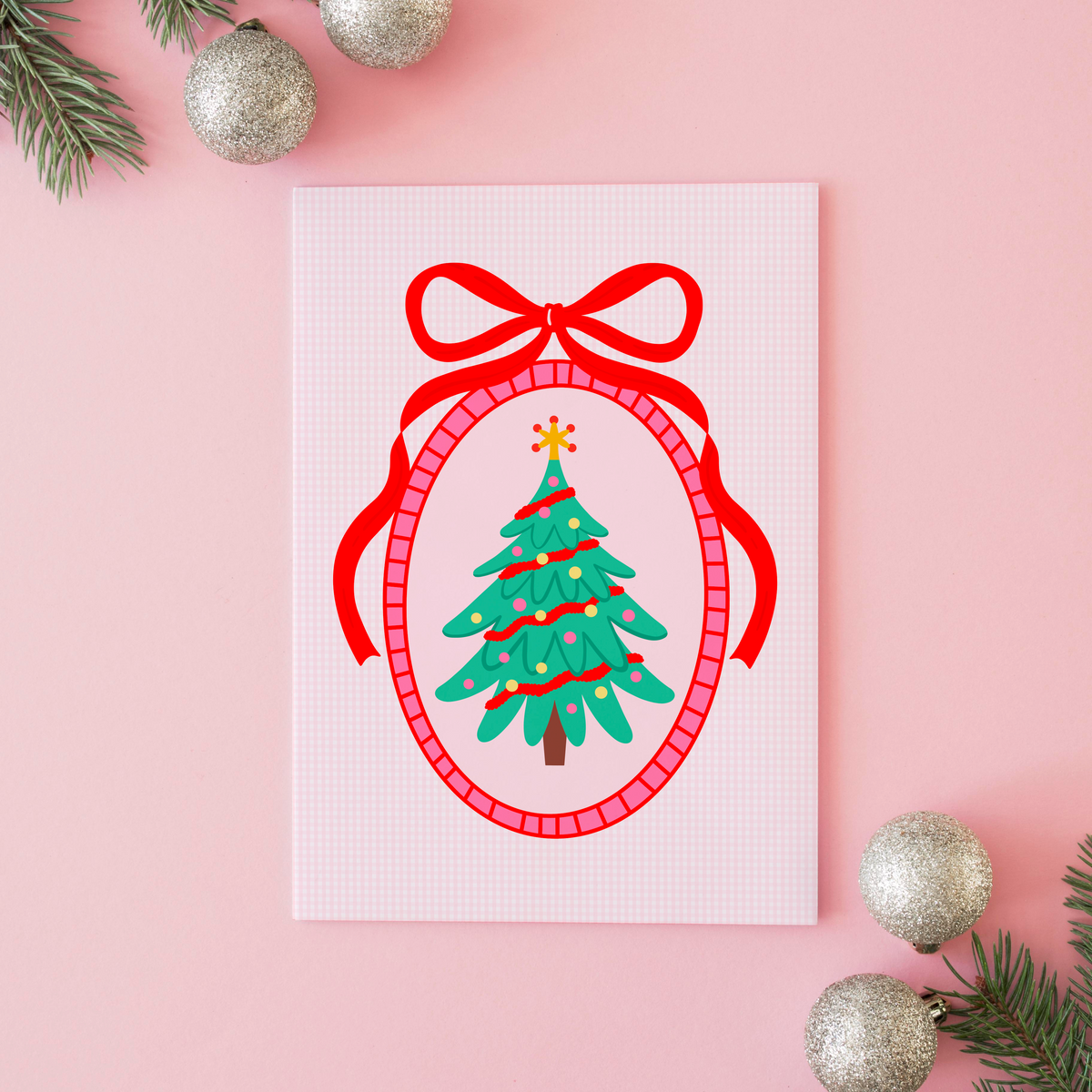An illustration of a Christmas tree, surrounded by a hand drawn border with a large red bow on top. The background of the print is a soft pink gingham.
