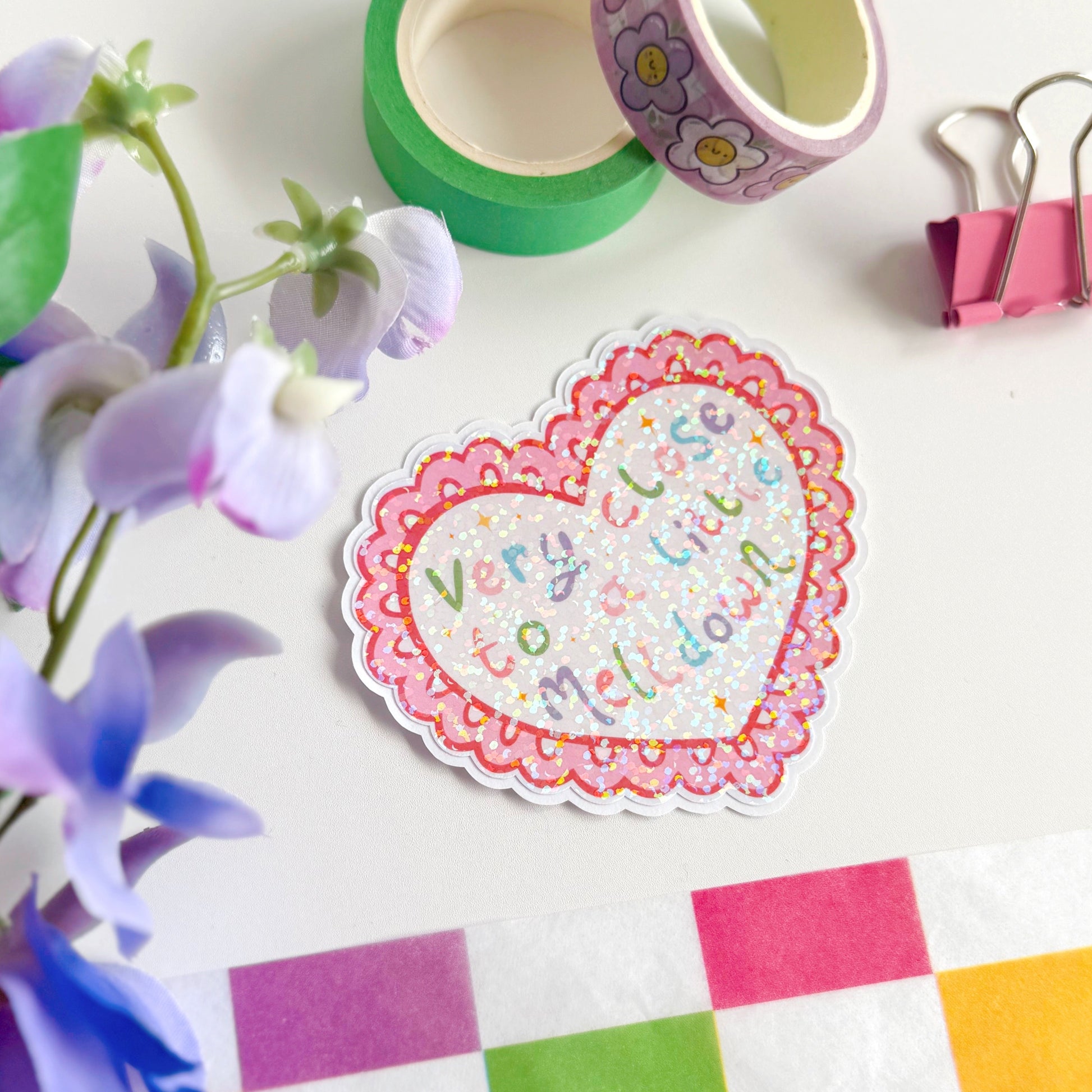 A scalloped edge heart, with hand lettered quote in the centre that reads 'very close to a little meltdown'.