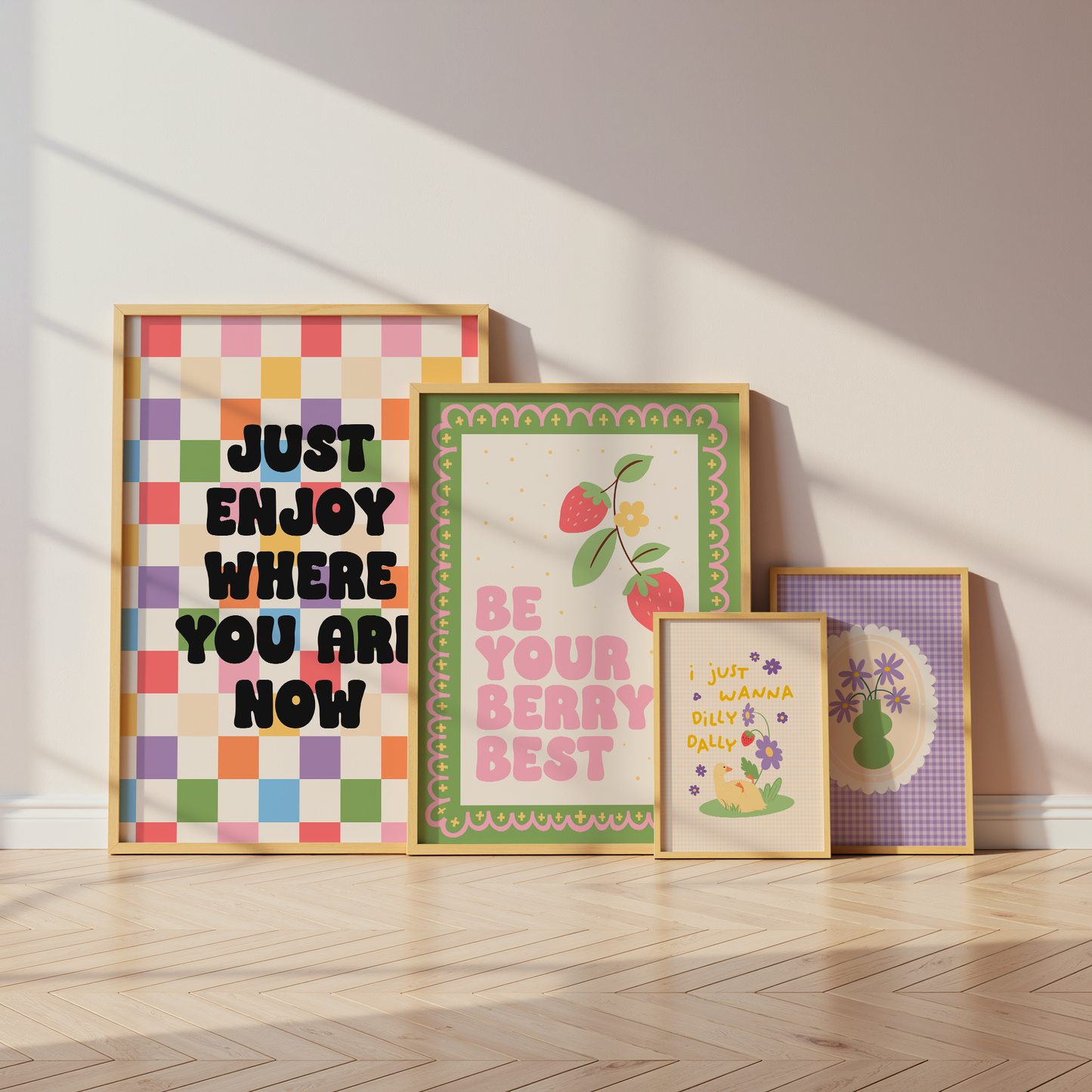 Four framed prints on a wooden floor with a light background