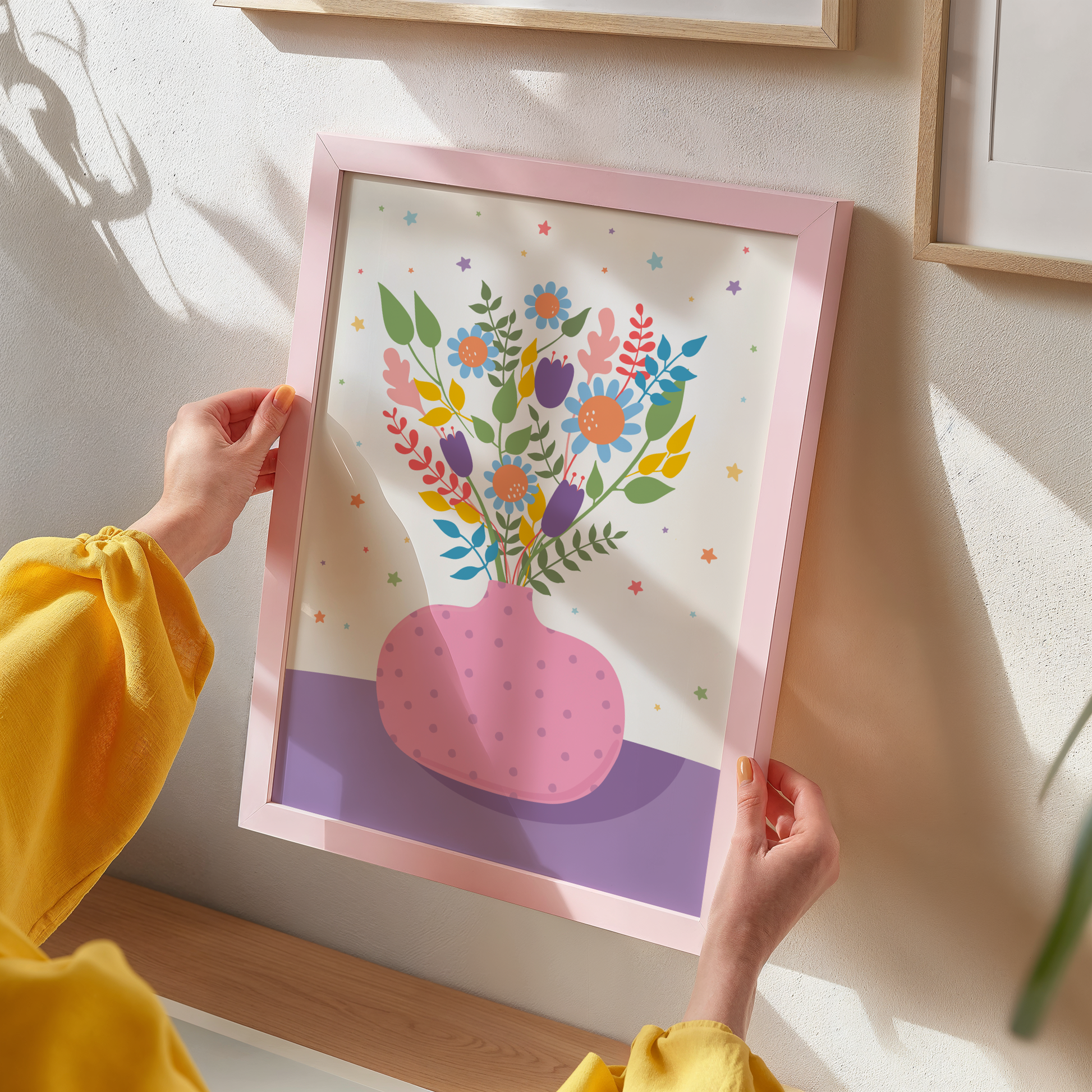 An illustration of a pink vase with bright colourful flowers in. The vase is set on a purple and cream background, decorated with little colourful star illustrations.