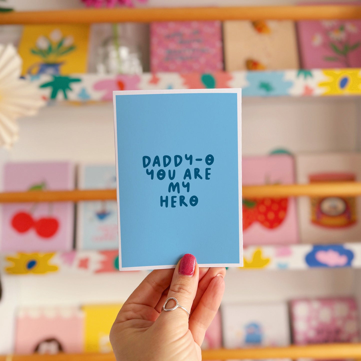 A blue greeting card with text that reads 'daddy-o you are my hero'.