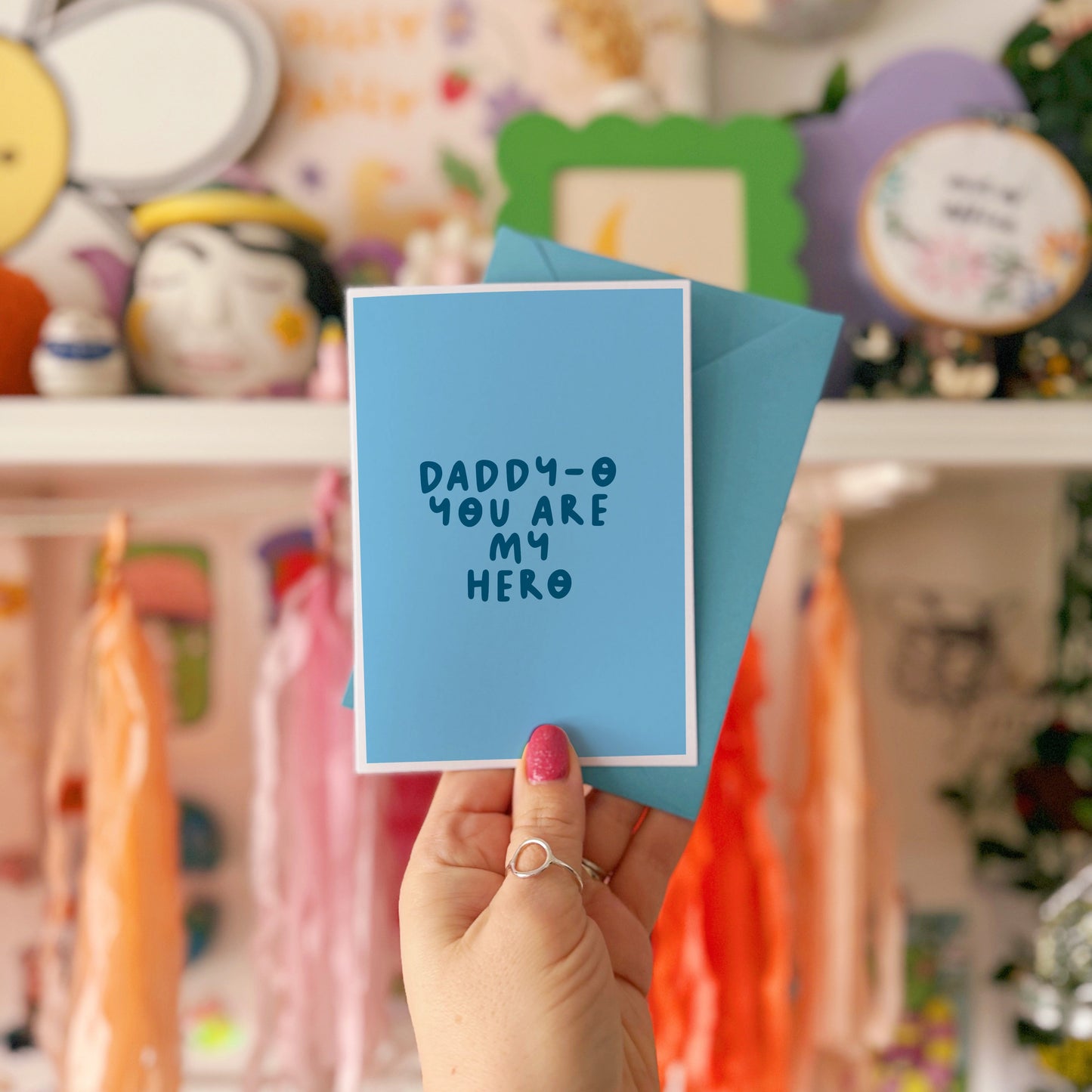 A blue greeting card with text that reads 'daddy-o you are my hero'.