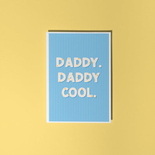 A blue greeting card with text that reads 'Daddy. Daddy Cool.' on the front with stars inside of the letters.