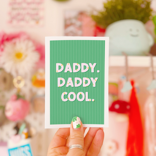 A green striped card, with white text saying 'daddy. daddy cool.' on the front. The text has little stars within the letting as well.