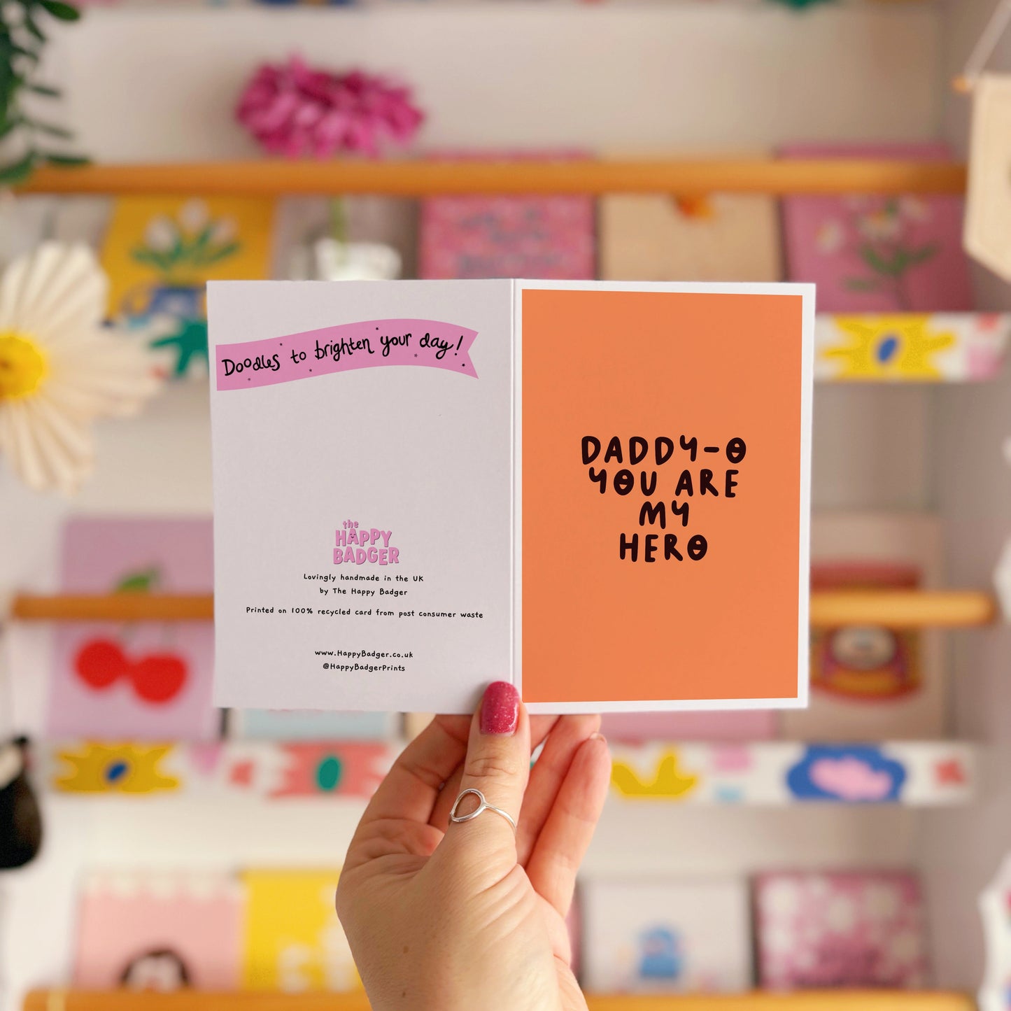 An orange greeting card with text in dark brown that says 'daddy-o you are my hero'.