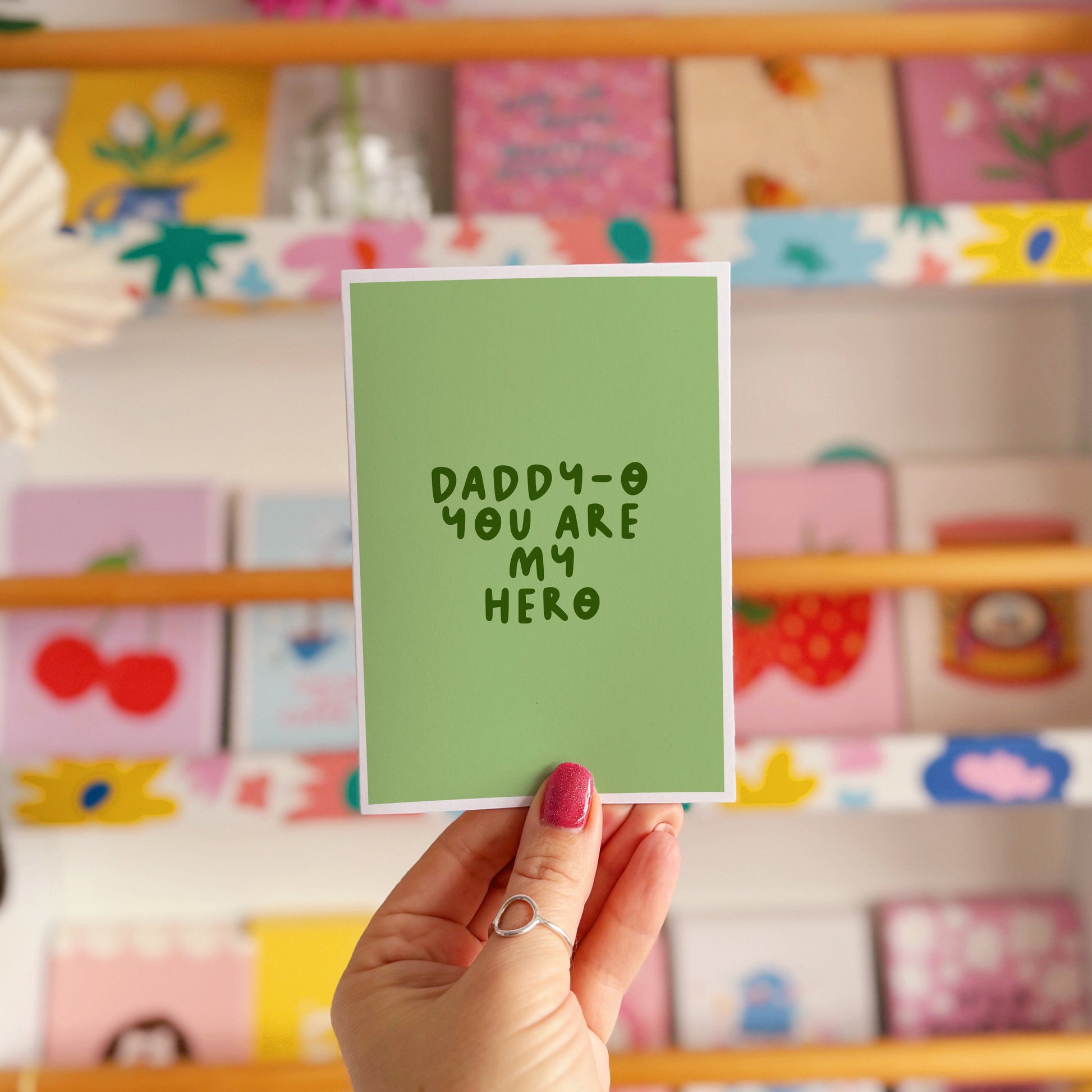 A green greeting card with text that reads 'Daddy-o you are my hero'.