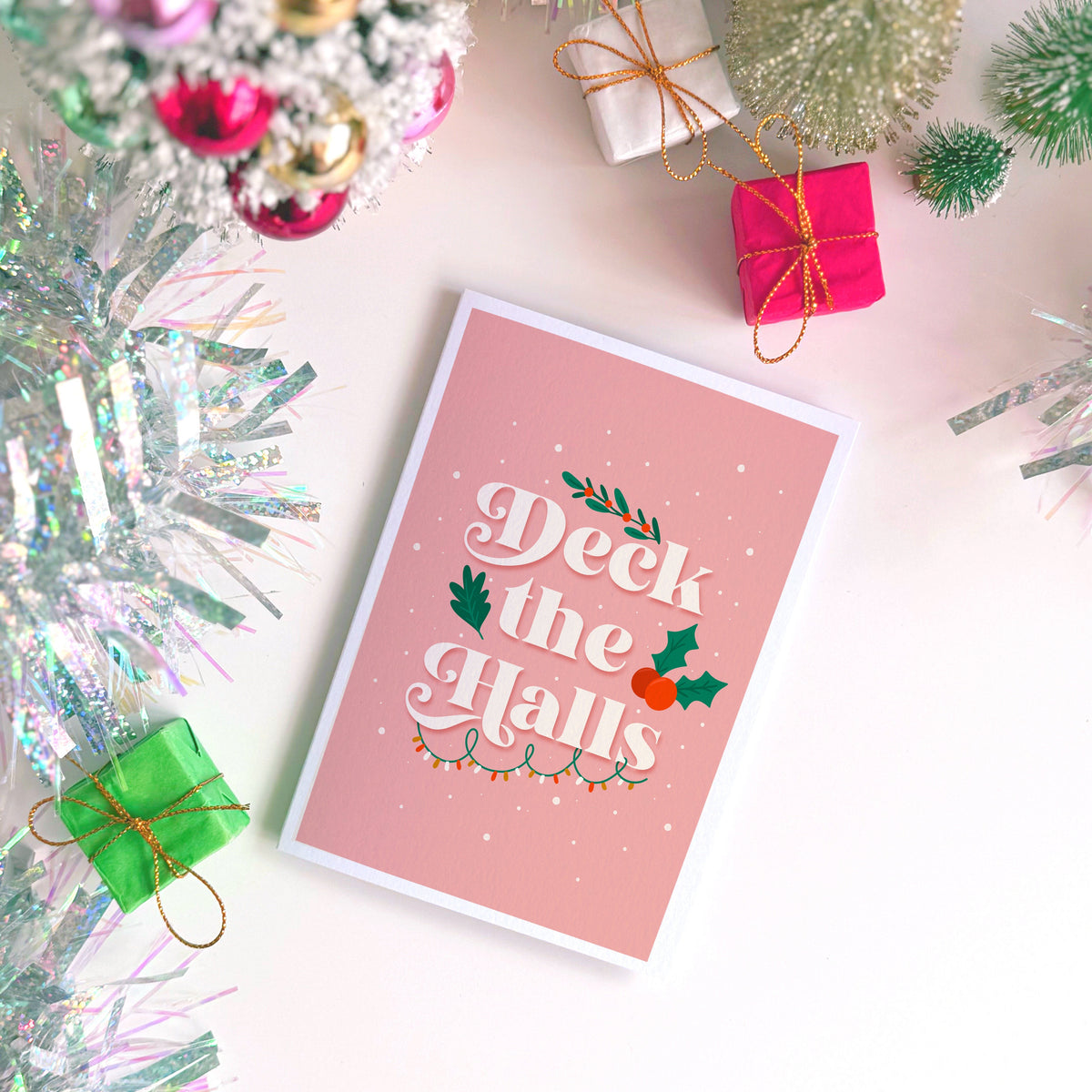 A Christmas card that has the words 'Deck The Halls' on the front.