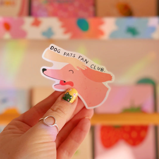 A waterproof sticker featuring an illustration of a dog with its tongue out and a hand patting its head. The text reads 'dog pats fan club'.